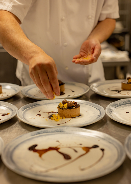 chef plating up a chocolate dessert
